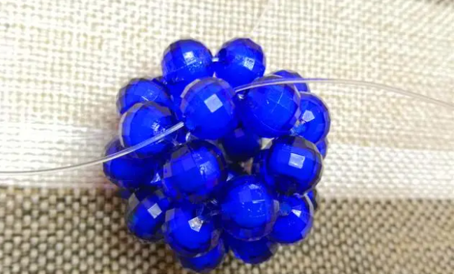 第十四步：右手線穿上兩顆珠子，并回穿與左線打結，形成如圖15的樣子