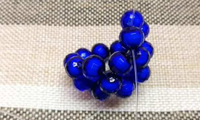 第十四步：右手線穿上兩顆珠子，并回穿與左線打結，形成如圖15的樣子