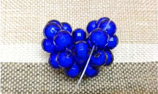 第十四步：右手線穿上兩顆珠子，并回穿與左線打結，形成如圖15的樣子