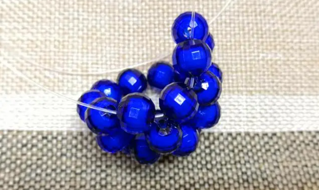 第十四步：右手線穿上兩顆珠子，并回穿與左線打結，形成如圖15的樣子