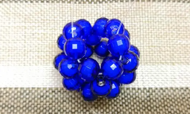 第十四步：右手線穿上兩顆珠子，并回穿與左線打結，形成如圖15的樣子