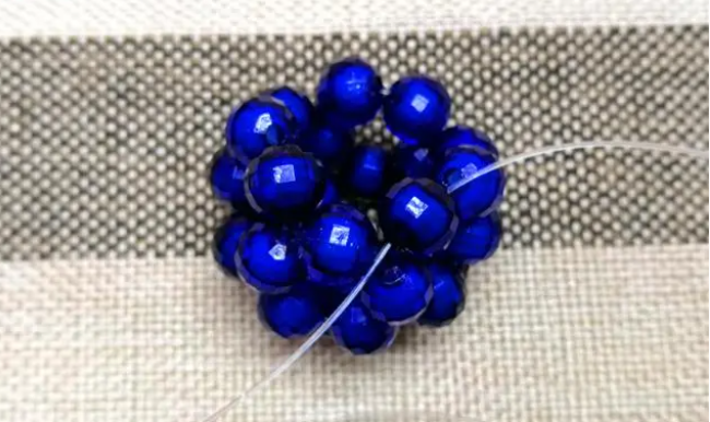 第十四步：右手線穿上兩顆珠子，并回穿與左線打結，形成如圖15的樣子