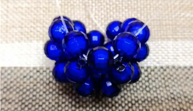 第十四步：右手線穿上兩顆珠子，并回穿與左線打結，形成如圖15的樣子